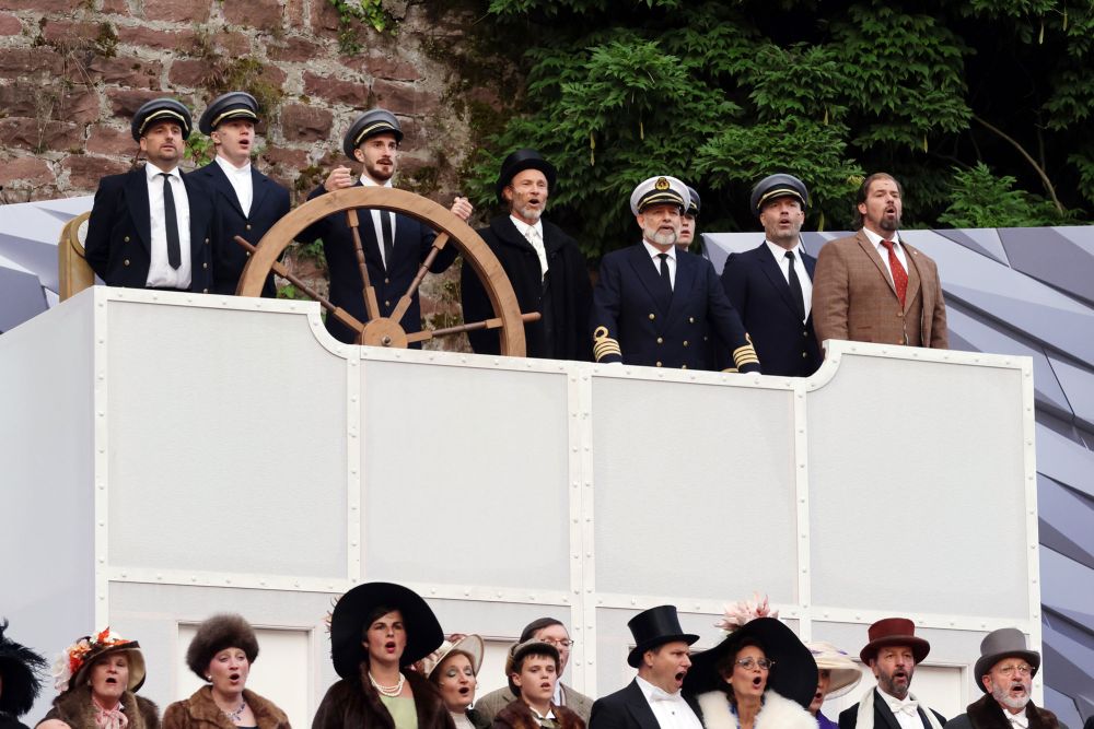 Schauspiel Chor auf der Bühne hinter einen Steuerrad