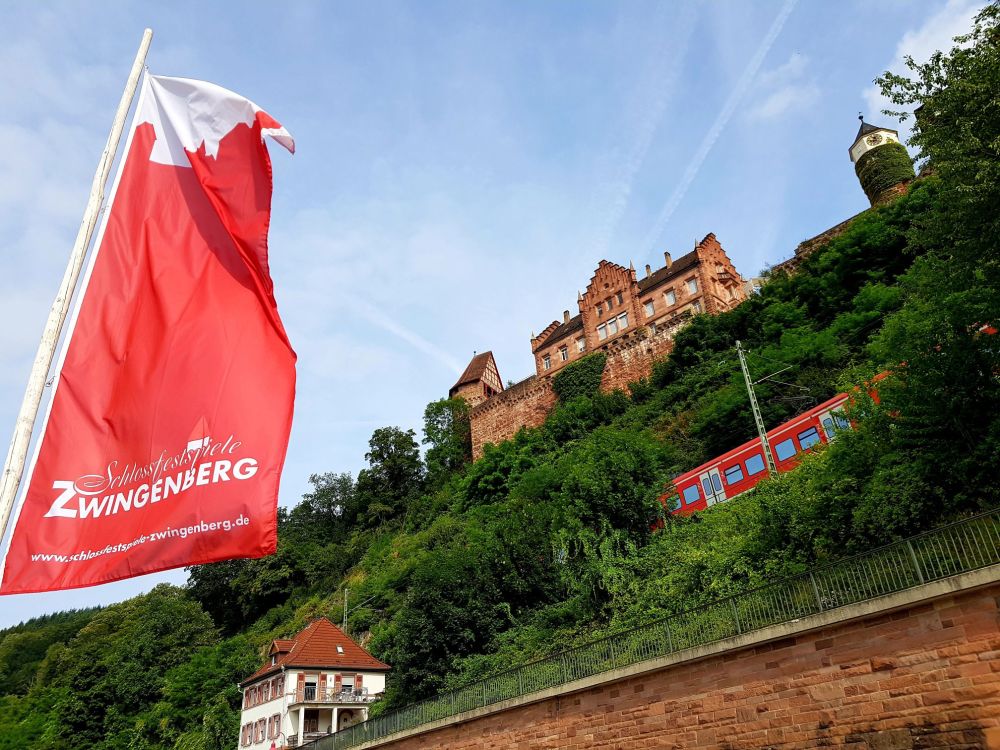 Schlossfestspielfahne mit Schloss und S-Bahn im Hintergrund