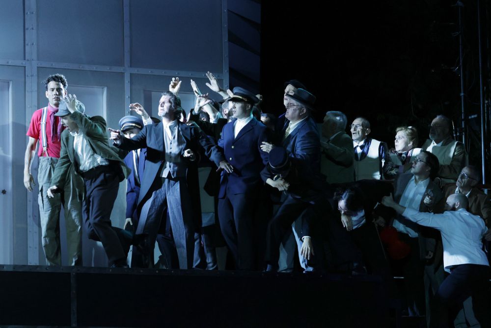 Viele Passagiere auf der Bühne in blauem Licht